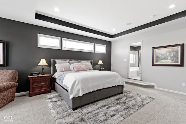 bedroom featuring recessed lighting, light colored carpet, baseboards, and connected bathroom