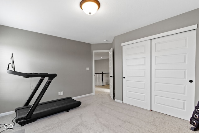 exercise room with baseboards and carpet