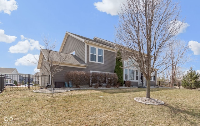 view of side of home featuring a lawn and fence