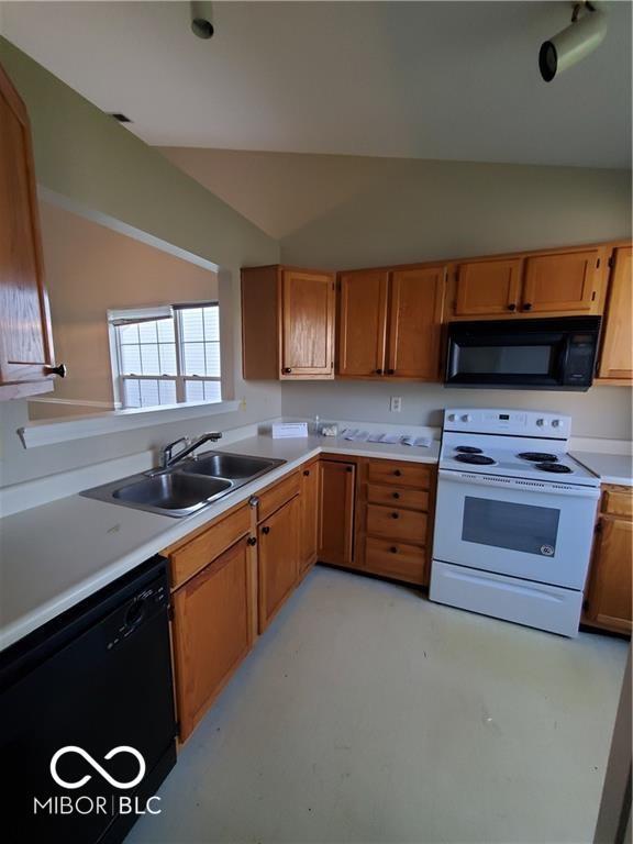 kitchen featuring vaulted ceiling, light countertops, a sink, and black appliances