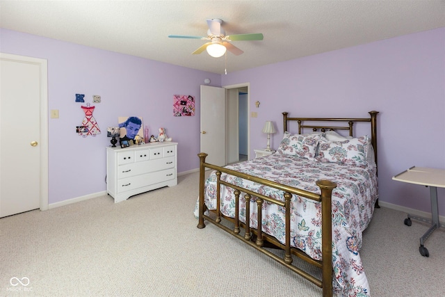 carpeted bedroom featuring ceiling fan, a textured ceiling, and baseboards