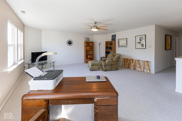 living area with a textured ceiling, carpet flooring, visible vents, and ceiling fan