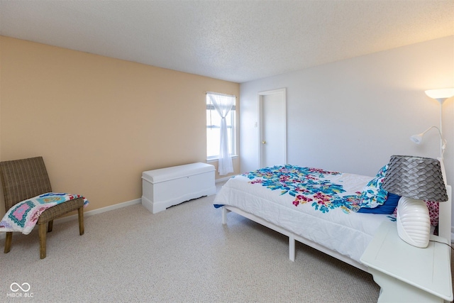 carpeted bedroom featuring baseboards and a textured ceiling