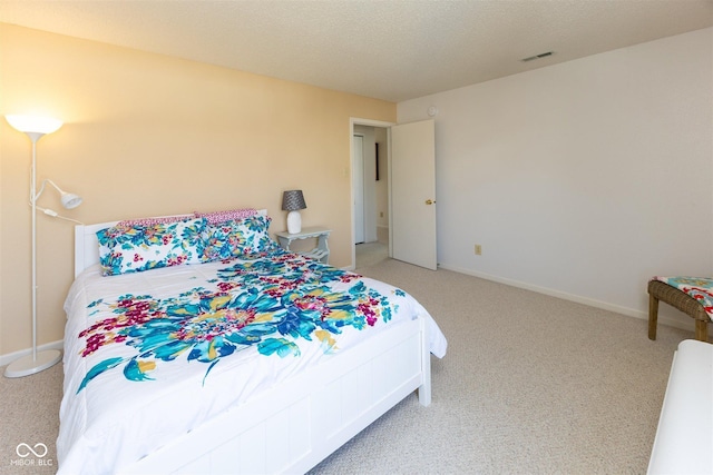 bedroom with visible vents, baseboards, light colored carpet, and a textured ceiling