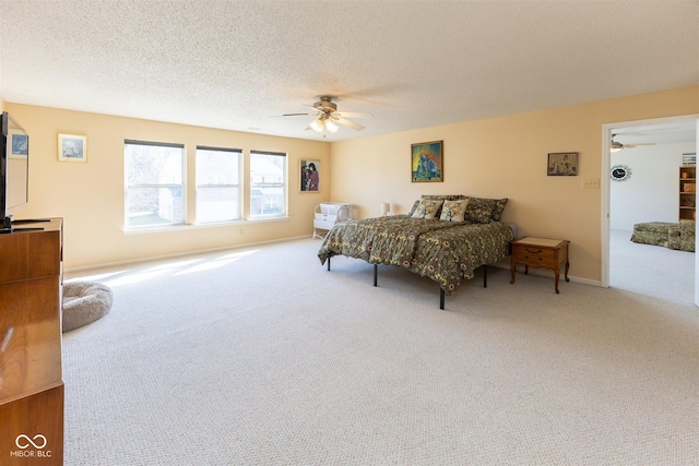 bedroom with baseboards, carpet floors, a textured ceiling, and a ceiling fan