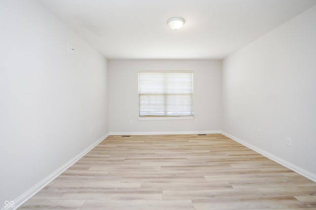 empty room with light wood finished floors and baseboards