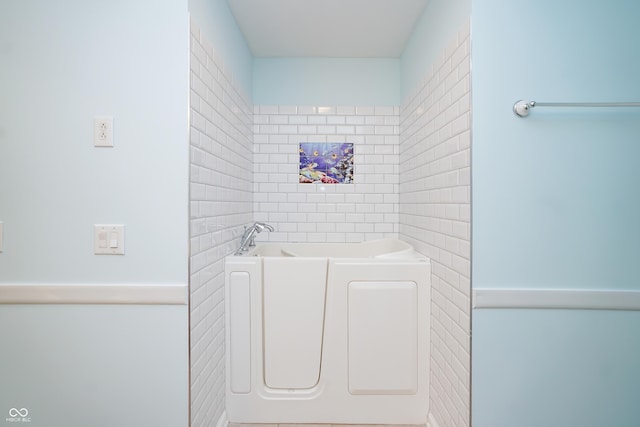 full bathroom featuring tile walls and a bath