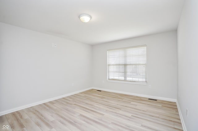 unfurnished room with visible vents, baseboards, and light wood-style floors