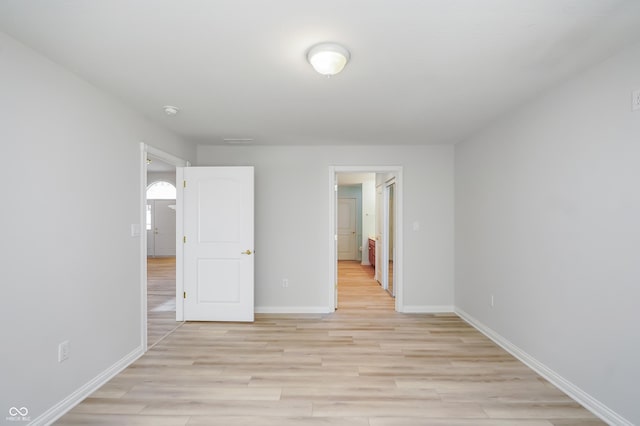 interior space with baseboards and light wood finished floors