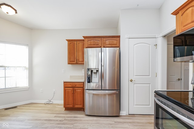 kitchen with light wood-style floors, visible vents, appliances with stainless steel finishes, and brown cabinets