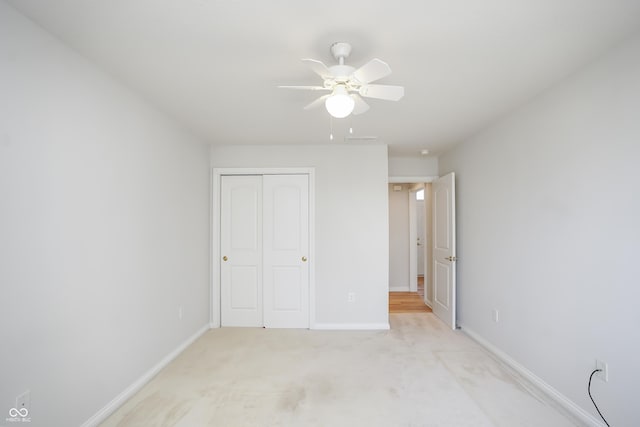 unfurnished bedroom with visible vents, baseboards, ceiling fan, light colored carpet, and a closet