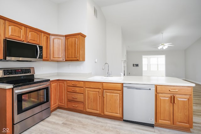 kitchen featuring visible vents, a sink, stainless steel appliances, a peninsula, and ceiling fan