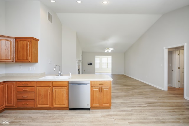 kitchen with a peninsula, ceiling fan, a sink, stainless steel dishwasher, and light wood-type flooring