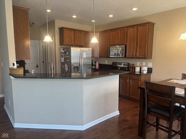14309 Shooting Star Dr, Noblesville, IN 46060 - kitchen featuring appliances with stainless steel finishes, dark wood-style flooring, brown cabinets, and recessed lighting