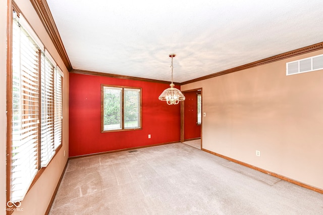 unfurnished room featuring visible vents, baseboards, an inviting chandelier, carpet, and crown molding