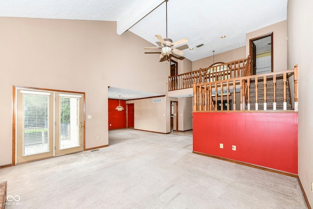 unfurnished living room featuring baseboards, ceiling fan, carpet floors, high vaulted ceiling, and beam ceiling