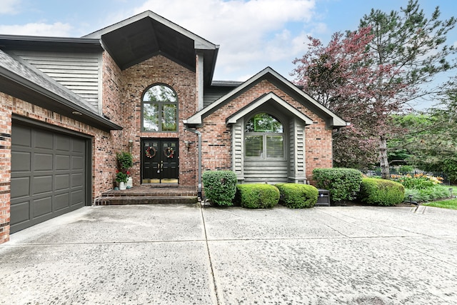 view of front of house featuring a garage, concrete driveway, and brick siding