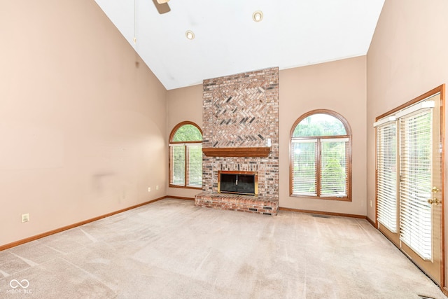 unfurnished living room with carpet floors, a brick fireplace, baseboards, and high vaulted ceiling