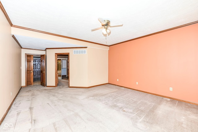 empty room with ceiling fan, light carpet, visible vents, baseboards, and ornamental molding