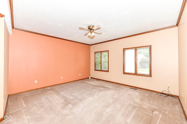 empty room featuring visible vents, baseboards, a ceiling fan, ornamental molding, and carpet