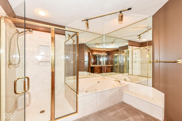 bathroom featuring a textured ceiling, a jetted tub, and a shower stall