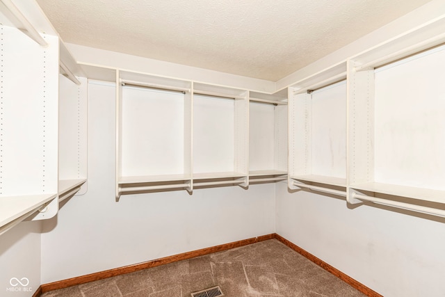 walk in closet featuring dark colored carpet and visible vents