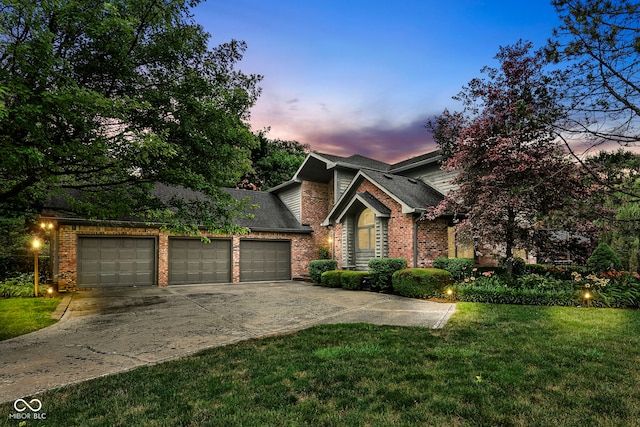 view of front of house featuring driveway, a garage, roof with shingles, a yard, and brick siding