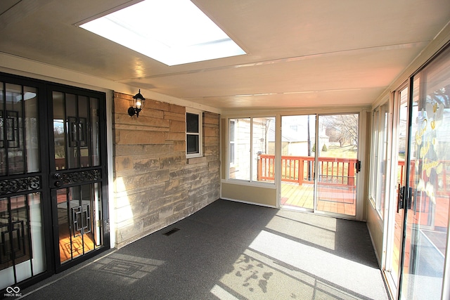 unfurnished sunroom with a skylight and visible vents