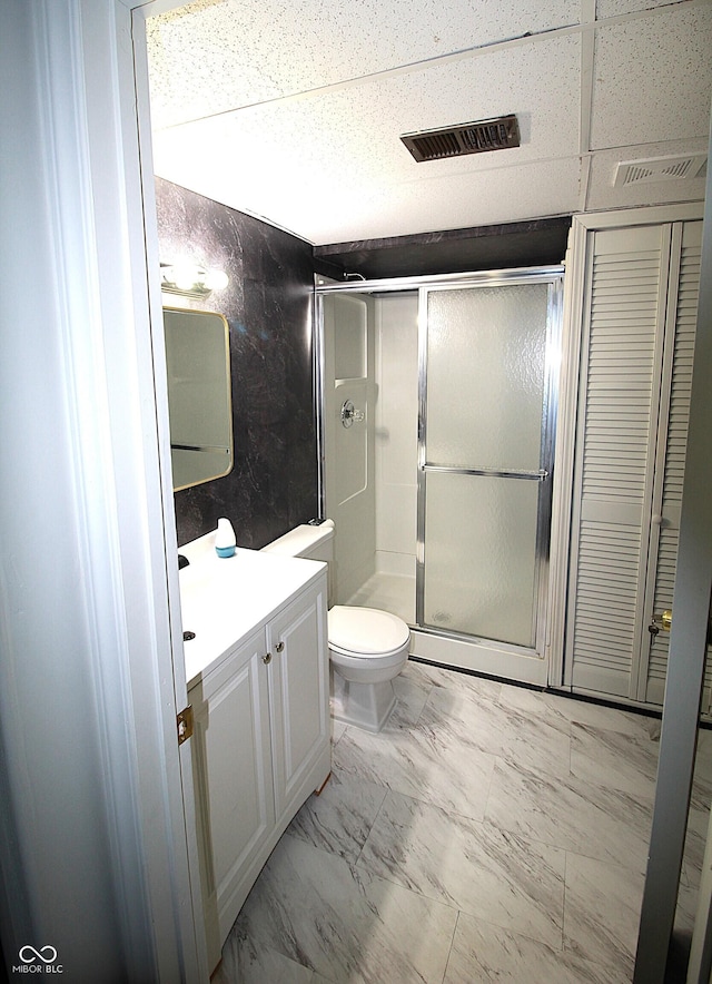 bathroom featuring marble finish floor, visible vents, toilet, a shower stall, and vanity