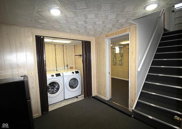 laundry area with laundry area, an ornate ceiling, washer and dryer, and wood walls