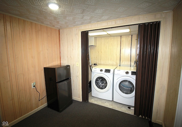 laundry room featuring laundry area, wood walls, baseboards, independent washer and dryer, and an ornate ceiling