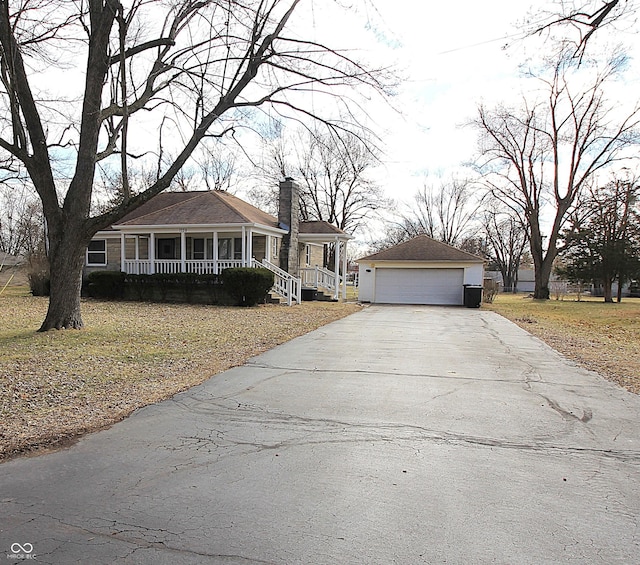 view of front of property with a garage, a chimney, a porch, and an outbuilding