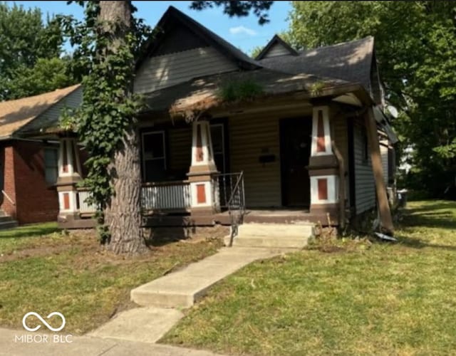 view of front of property featuring covered porch and a front lawn