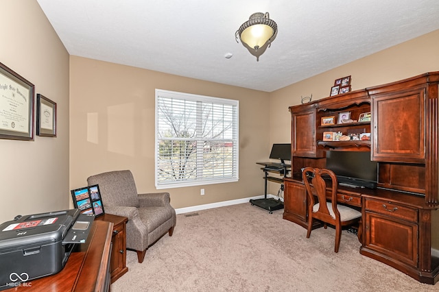 office area featuring baseboards, light carpet, and a textured ceiling