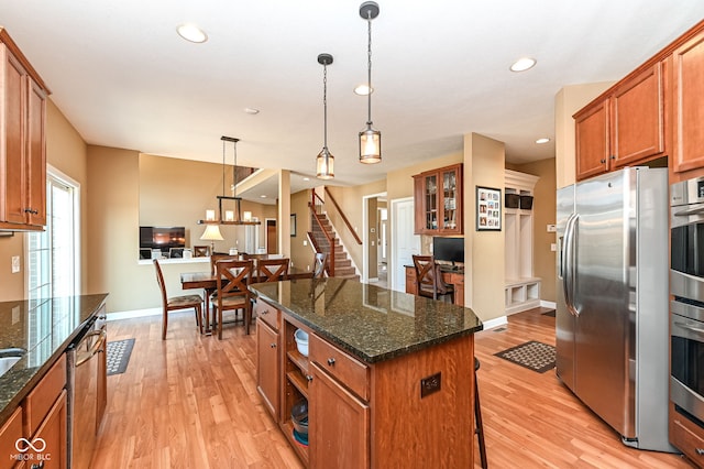 kitchen featuring light wood-style flooring, a center island, brown cabinetry, and stainless steel appliances