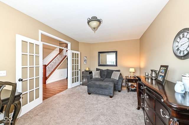 living area with french doors and light carpet