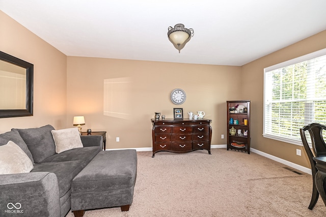 living area with visible vents, baseboards, and carpet flooring