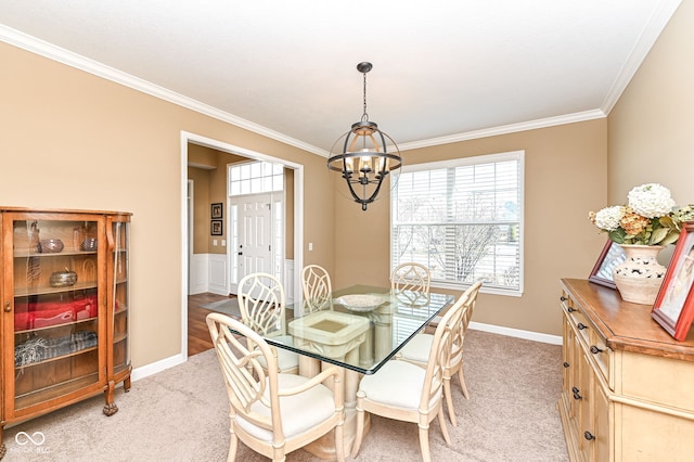 dining room featuring baseboards, light colored carpet, a chandelier, and crown molding