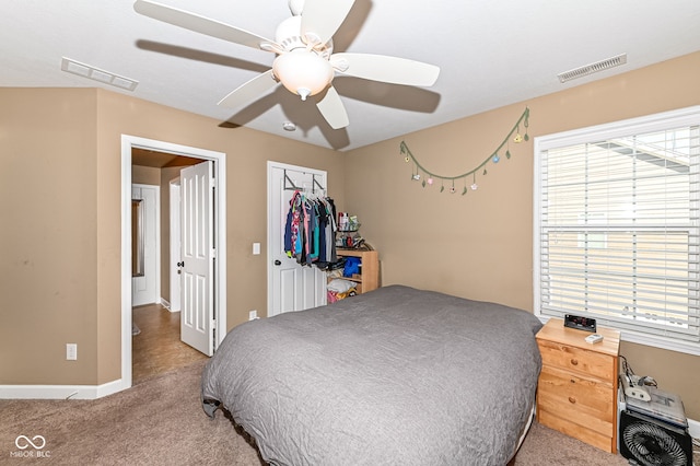 carpeted bedroom with visible vents, baseboards, a closet, and ceiling fan