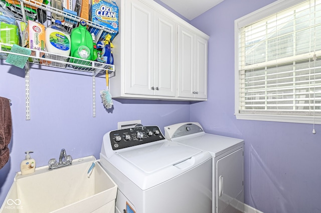 laundry room with a sink, a wealth of natural light, washing machine and dryer, and cabinet space