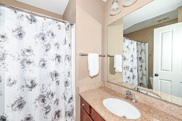 bathroom with visible vents, curtained shower, toilet, and vanity