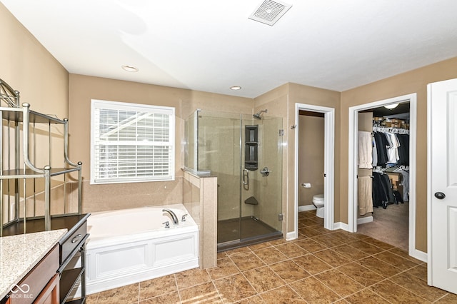 bathroom with visible vents, toilet, a shower stall, a bath, and vanity