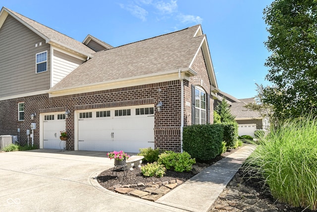 14034 Wicklow Ln, Fishers, IN 46040 - view of side of home featuring brick siding, roof with shingles, an attached garage, and concrete driveway