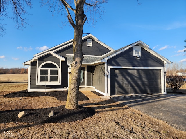 single story home with aphalt driveway and an attached garage