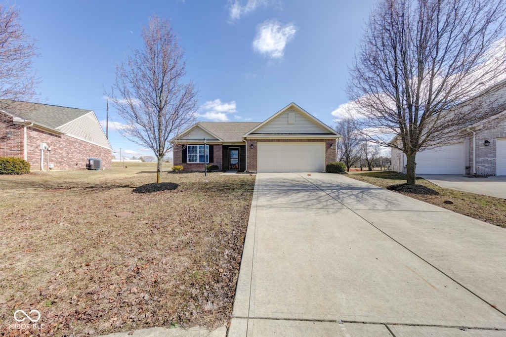 ranch-style house with driveway, brick siding, an attached garage, central air condition unit, and a front yard