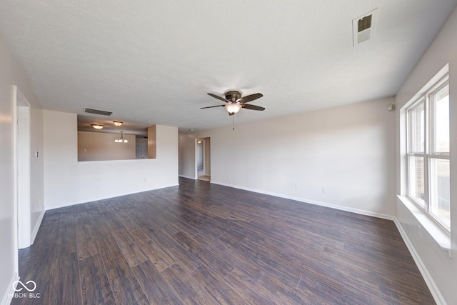 spare room with baseboards, visible vents, dark wood finished floors, and a ceiling fan