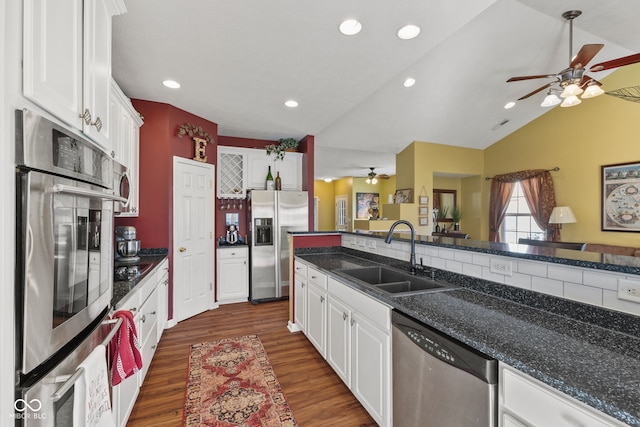 kitchen featuring recessed lighting, dark wood-type flooring, a sink, white cabinetry, and appliances with stainless steel finishes