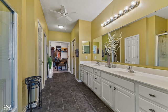 full bath featuring double vanity, an enclosed shower, a sink, and tile patterned floors