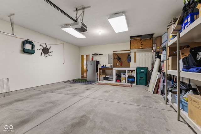 garage with freestanding refrigerator and a garage door opener