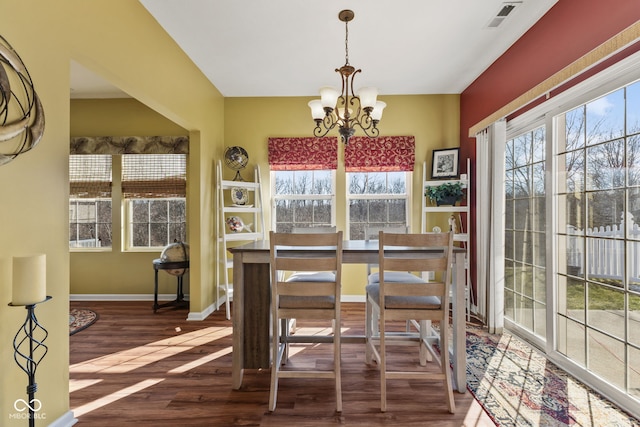 dining room with wood finished floors, visible vents, baseboards, and an inviting chandelier